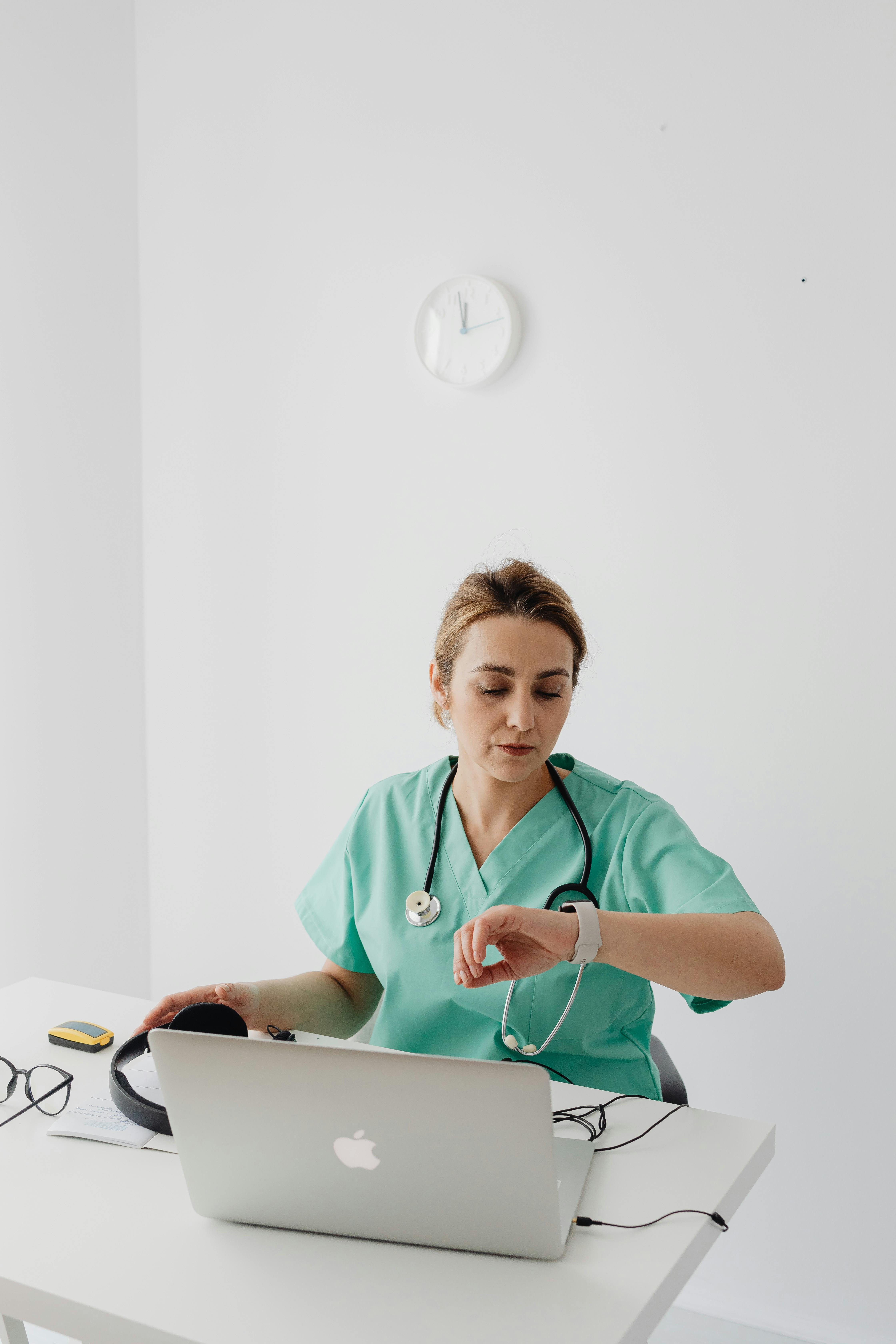 Infirmière sur ordinateur vérifiant l'heure